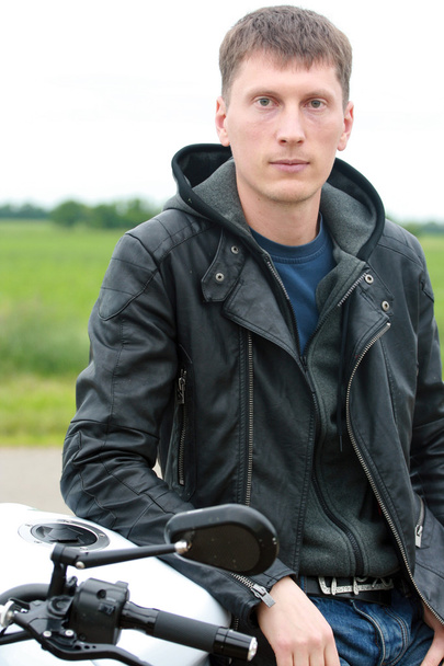 Νεαρός άνδρας κοντά μια μοτοσικλέτα - Φωτογραφία, εικόνα