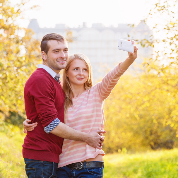 Jovem casal apaixonado ao ar livre tomando selfie
 - Foto, Imagem