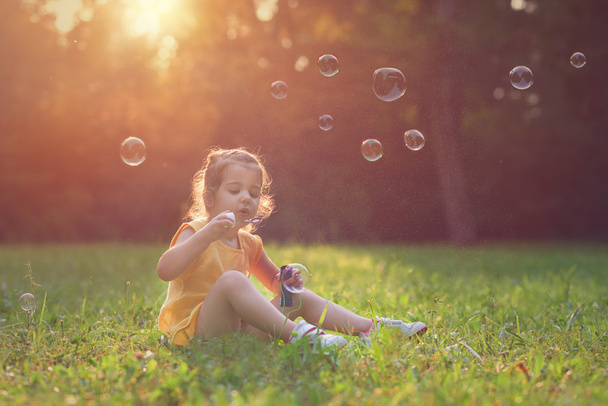 Κοριτσάκι παίζει με σαπούνι μπαλόνια. - Φωτογραφία, εικόνα