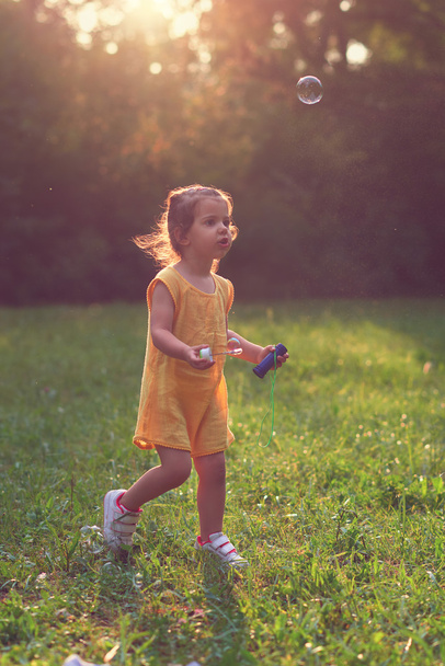 Little girl playing with soap balloons. - Valokuva, kuva