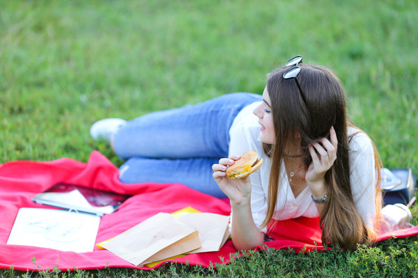 travail féminin couché dans des lunettes dans le parc et collation alimentaire
 - Photo, image