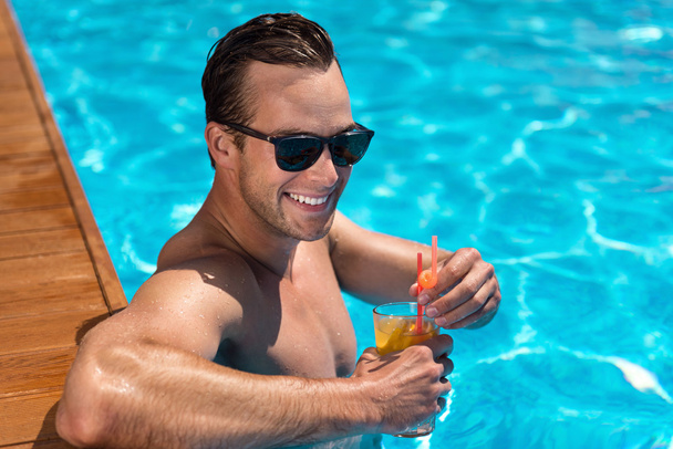 Delighted man resting in the swimming pool - Photo, Image