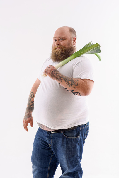 Barbuto maschio grasso tenendo porro
 - Foto, immagini