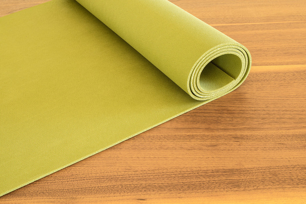 Yoga mat on a wooden background. - Foto, afbeelding