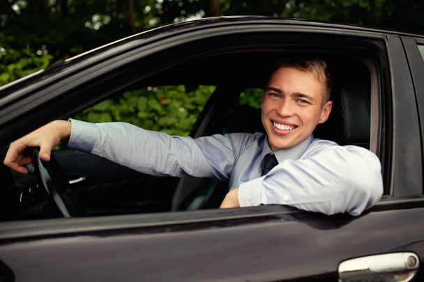 Young man sitting in the car smiling - Valokuva, kuva
