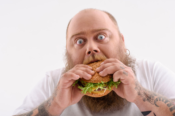 Fat guy eating unhealthy food - Fotoğraf, Görsel