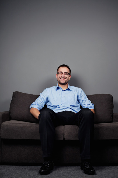 Man sitting on sofa - Valokuva, kuva
