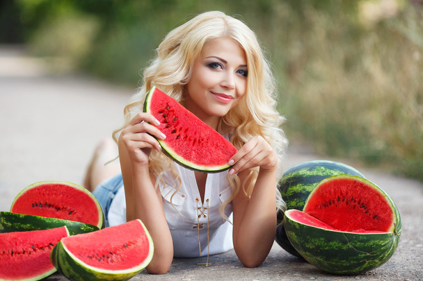 Beautiful young woman holding a slice of ripe watermelon - Foto, afbeelding