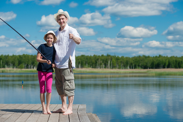 Dad and daughter caught a fish on a river - Foto, Imagem