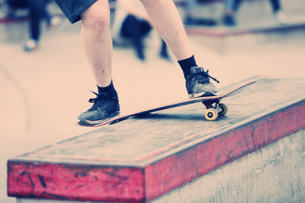 Skater grinding on a ledge in skatepark - Foto, afbeelding