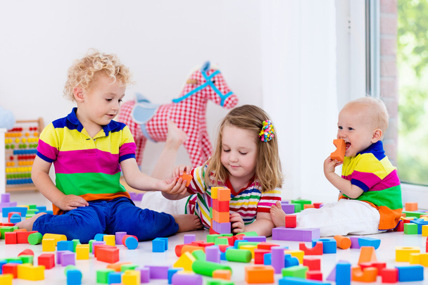 Kinderen spelen met kleurrijke speelgoed blokken - Foto, afbeelding