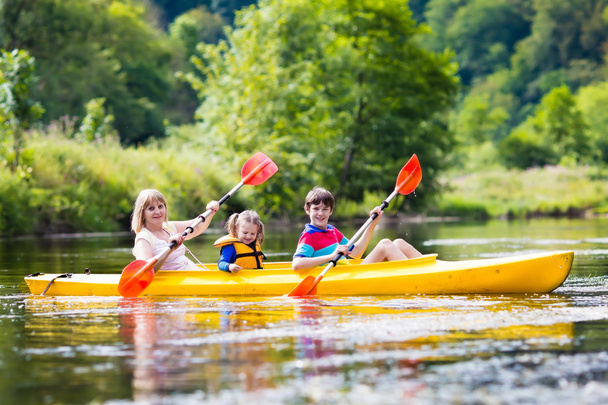 Familia disfrutando del paseo en kayak por un río
 - Foto, Imagen