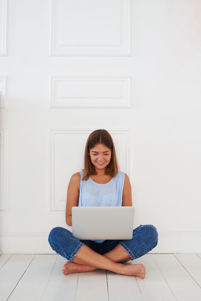 Jeune fille moderne utilisant son ordinateur portable avec expression faciale joyeuse
 - Photo, image
