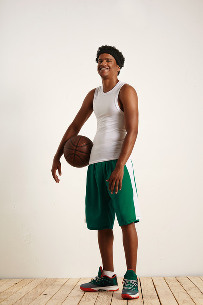 athlete standing with basketball under arm - Valokuva, kuva
