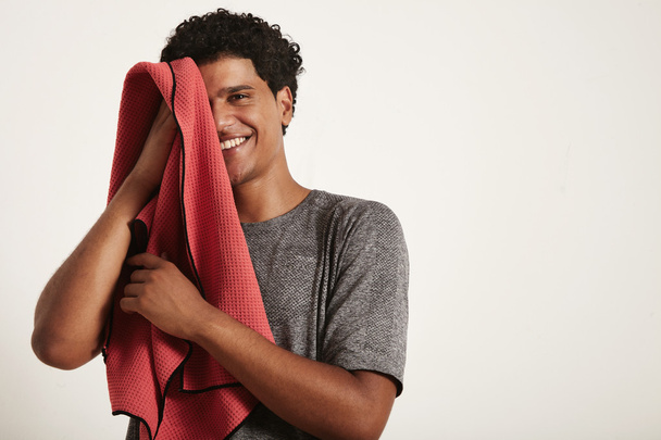 sportsman wiping face with towel and right half of face open - Foto, afbeelding