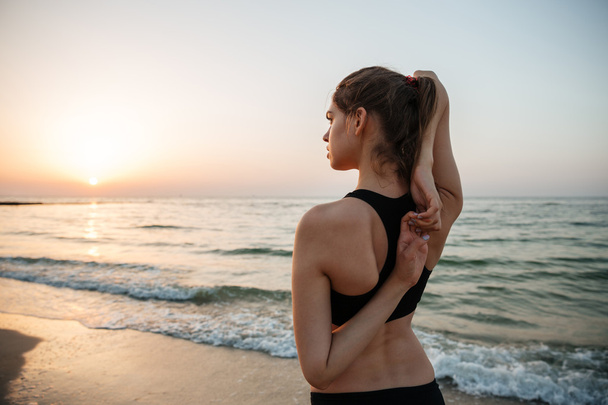 Kaunis nuori nainen venyttely joogan aikana rannalla
 - Valokuva, kuva