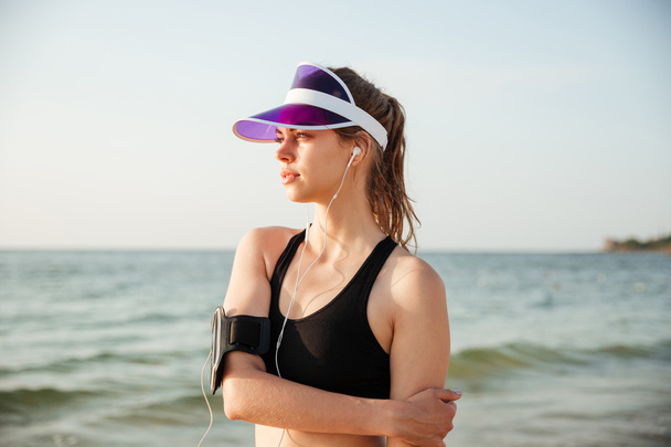 Fitness runner doing warm-up routine on beach before running - Photo, Image