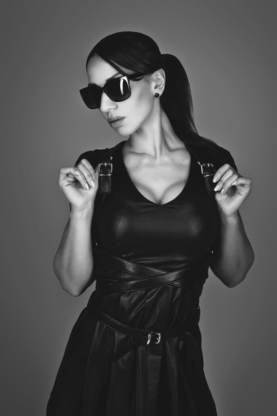 Beautiful girl in leather dress and sunglasses - Photo, Image