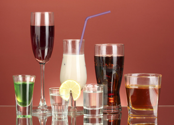 A variety of alcoholic drinks on red background - Fotó, kép