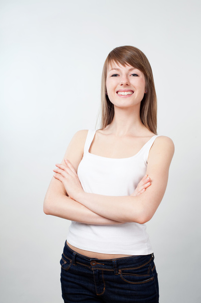 Young woman standing with crossed arms. Smiling - Foto, afbeelding