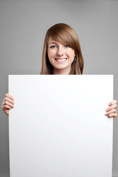 Attractive woman with blank sign. Smiling. - Valokuva, kuva