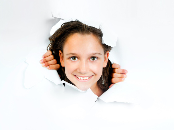 Little girl looks with sheet of torn white paper - Photo, Image