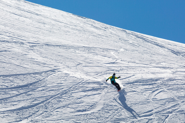Homem snowboarder snowboard na neve branca fresca na pista de esqui no dia ensolarado de inverno
 - Foto, Imagem