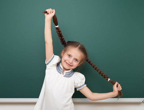 school student meisje open armen op schone blackboard, grimassen en emoties, gekleed in een zwart pak, onderwijs concept, studio foto - Foto, afbeelding