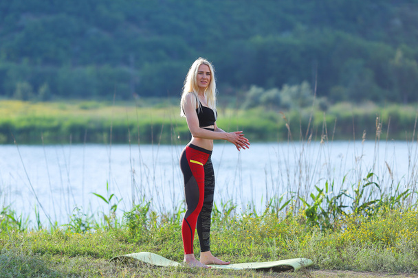 Mladá krásná žena dřepy ukazuje výsledek tisku na žaludek cvičení školení na sobě top - Fotografie, Obrázek