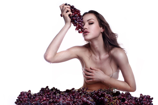 Красива молода жінка грає їсть з виноградом
 - Фото, зображення