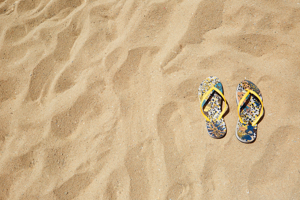 Closeup Beach Sandals Flip Flops or Tongs Sandy  Background Copyspace. Summer Concept. Horizontal. No body photo. - Foto, afbeelding