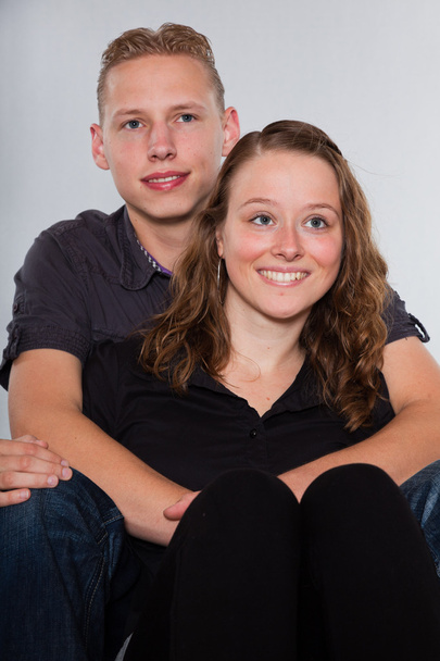 Happy young couple casual dressed. Studio shot isolated on grey background. Man with short blond hair. Woman long brown hair. - Zdjęcie, obraz