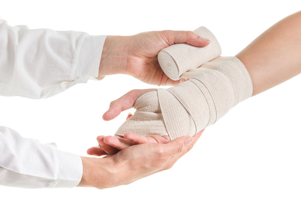 Doctor imposes an elastic bandage to the patient's hand - Photo, image