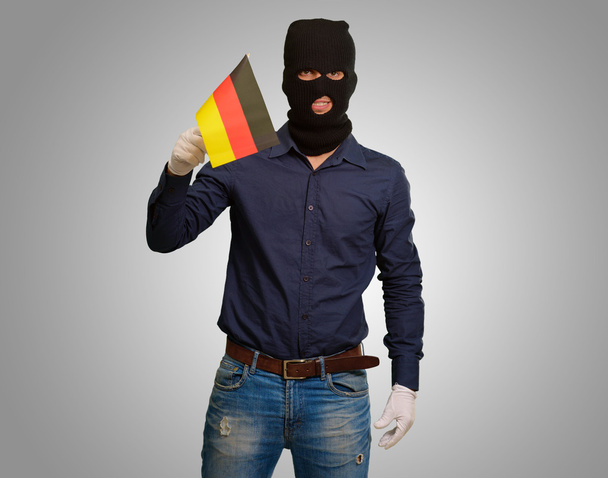 άνθρωπος φορώντας μάσκα ληστής και κρατώντας την σημαία - Φωτογραφία, εικόνα