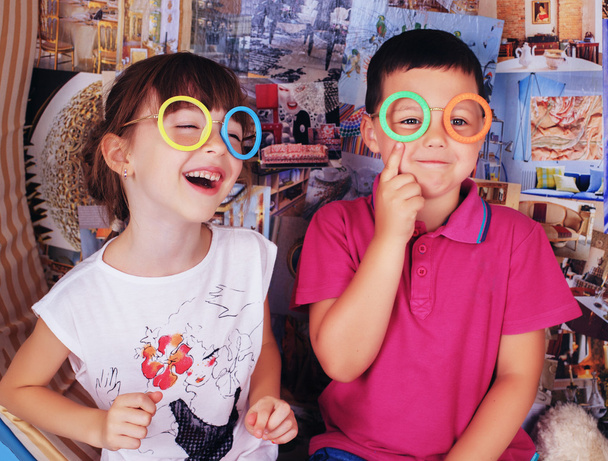 Τα παιδιά γελούν και παίζουν με τα γυαλιά και το μουστάκι - Φωτογραφία, εικόνα