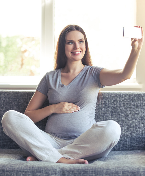 Beautiful pregnant woman at home - 写真・画像