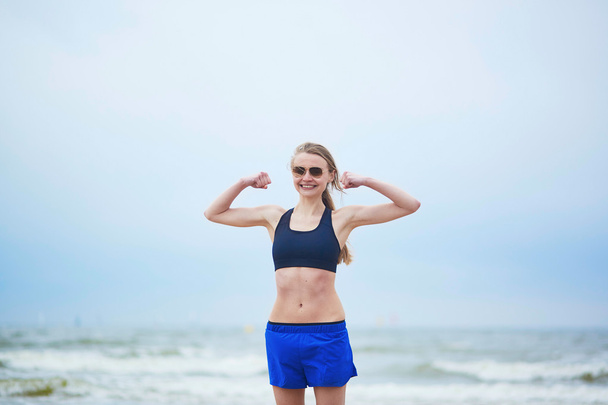 Fitness saine coureuse fille montrant ses biceps
 - Photo, image