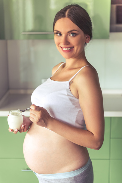 Pregnant woman in the kitchen - Fotoğraf, Görsel