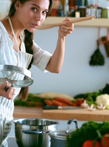 Cooking woman in kitchen with wooden spoon - 写真・画像