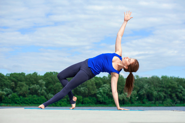 Young woman doing yoga exercise on mat03 - Фото, зображення