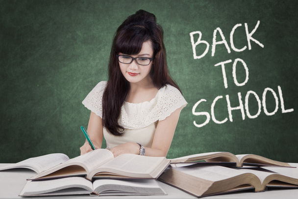 Schoolgirl studying with text Back to School - Фото, изображение