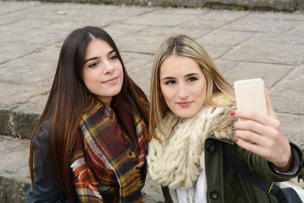 Two young girlfriends taking selfie with smartphone. - Foto, imagen