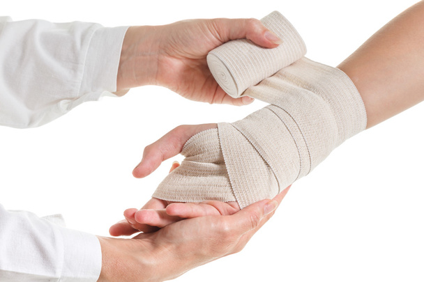 Doctor imposes an elastic bandage to the patients hand - Foto, Imagen
