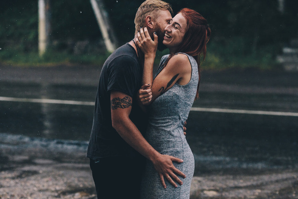 雨の中で抱いて美しいカップル - 写真・画像