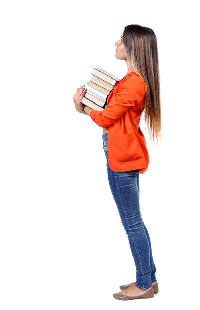 Girl carries a heavy pile of books. back view. - Zdjęcie, obraz