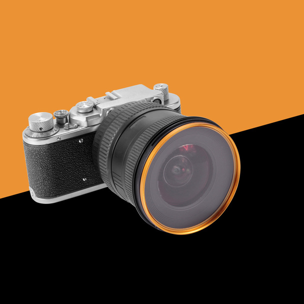 Retro film camera oranje en zwarte achtergrond - Foto, afbeelding