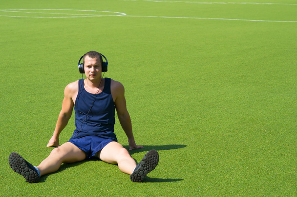 on the football field, a man sitting - Foto, Bild