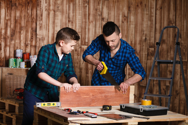 construction of father and son in the garage, family concept - Фото, изображение
