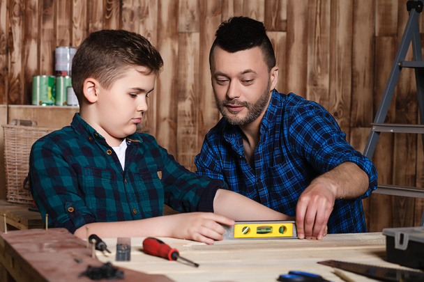 construction of father and son in the garage, family concept - 写真・画像
