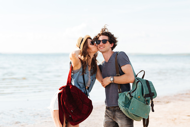 Joyeux jeune couple debout à la plage et embrasser
 - Photo, image